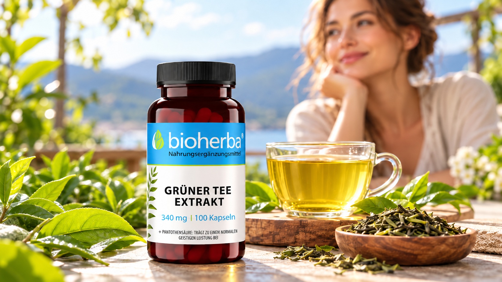 Bioherba Gr&uuml;ner Tee Extrakt 340 mg &ndash; 100 Kapseln im Vordergrund neben einer Tasse Gr&uuml;ntee und Teebl&auml;ttern, mit einer Frau und einem See im Hintergrund.