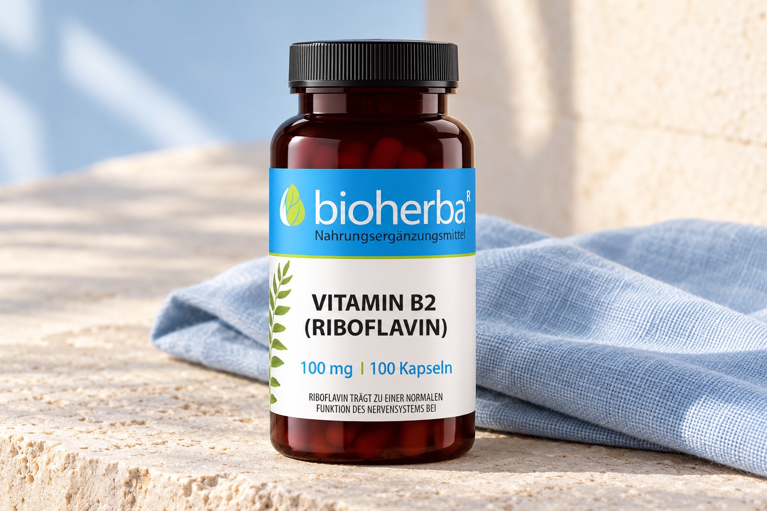 Bioherba Vitamin B2 Riboflavin 100 mg auf hellem Stein mit blauem Leinen &ndash; KI-generierte Produktdarstellung